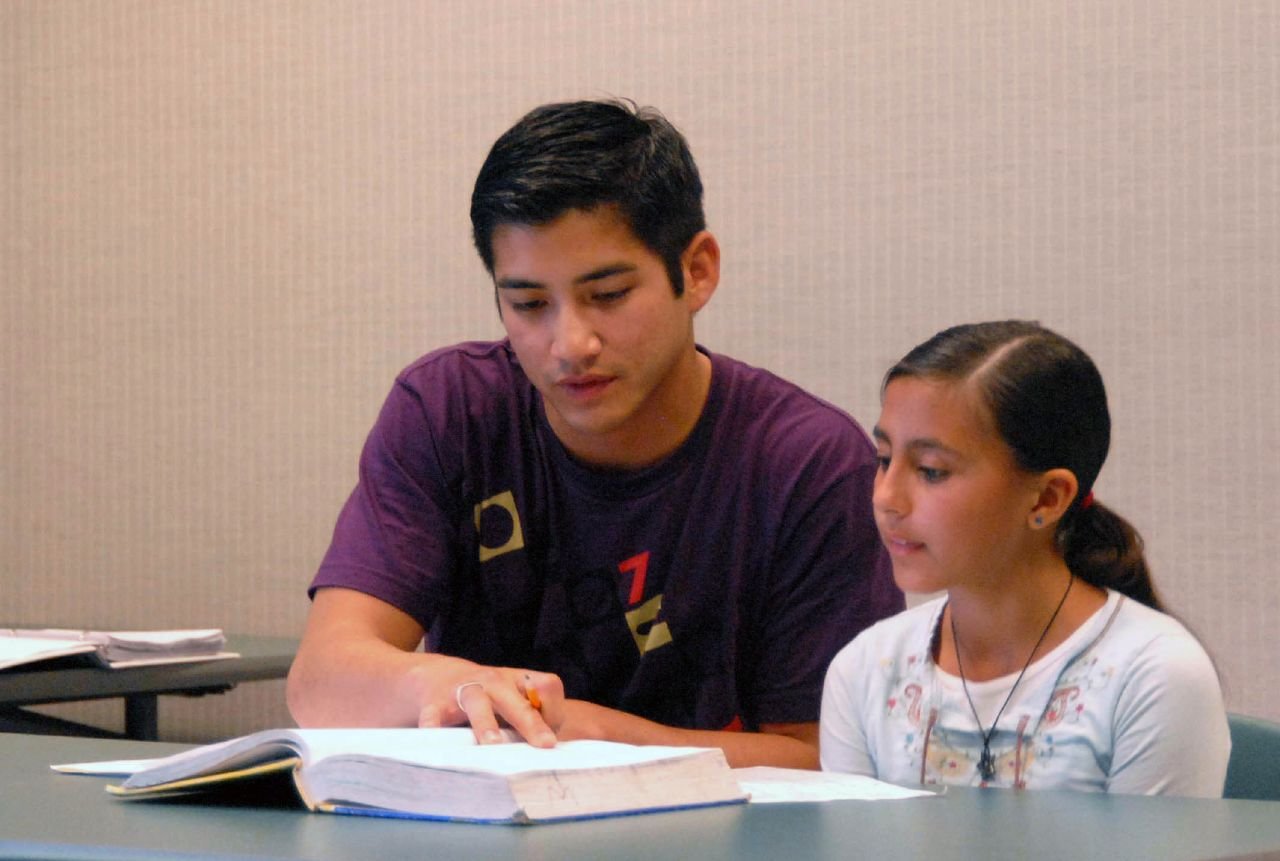 Second Lt. Patrick Leary, 412th Test Support Squadron acquisition manager, helps Vanessa Olmos, a local student, with her mathematics homework. About 20 Edwards company grade officers volunteer their time and effort at the Wanda Kirk Rosamond Library to help children prepare for math tests, homework and make-up work. (Photo by Airman Mike Young)